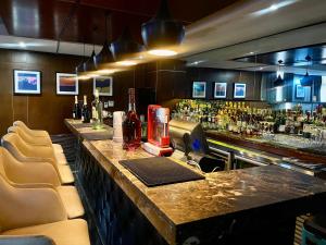 a bar with chairs and a counter with bottles of alcohol at The Sojourner By Genesis in Ikeja