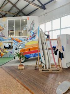 a room with surfboards and a room with a car at WOT Peniche Social in Peniche