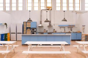 a large kitchen with blue cabinets and benches at WOT Peniche Social in Peniche