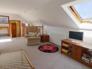 ein Wohnzimmer mit Fernseher und Sessel in der Unterkunft Spring Cottage in Lynton