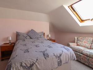 ein Schlafzimmer mit einem Bett und einer Couch in der Unterkunft Spring Cottage in Lynton