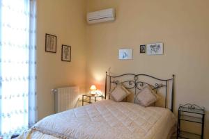 a bedroom with a bed with a white comforter and a window at Casa Vacanza Albamarina in Trapani