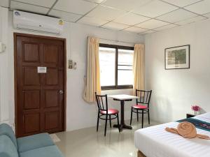 a bedroom with a bed and a table and chairs at JJ karon beach hotel in Karon Beach