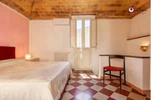 a bedroom with a bed and a red chair at Casa Nel Borgo - WelcHome in Lanciano