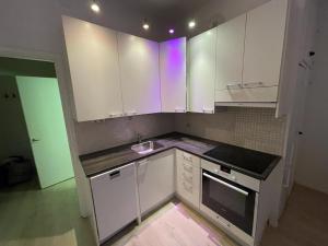a small kitchen with white cabinets and a sink at Smart 32m2 studio in a central location - Kallio in Helsinki