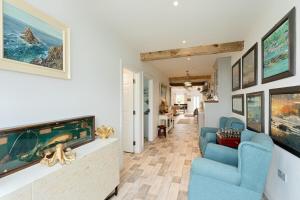 a living room with blue chairs and paintings on the wall at Holland House No3 in Liscannor
