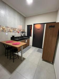 a kitchen with a wooden table and a wooden door at Casa Lua Flat in Brumadinho