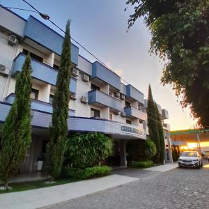 a building with a car parked in front of it at Hotel Asa Branca in Belo Jardim