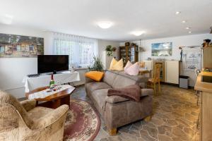 a living room with a couch and a tv at Ferienwohnung im Burgenland in Schleberoda