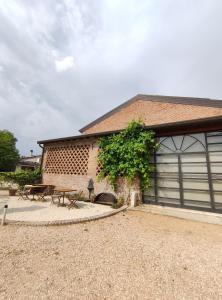a building with two garage doors and a tree at B&B Rocambola in Nogara