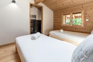 zwei Betten in einem Zimmer mit Fenster in der Unterkunft Les Trabets - Bellevue telecabine - Renove in Les Houches