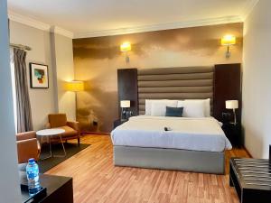 a hotel room with a bed and a table and chairs at The Sojourner By Genesis in Ikeja