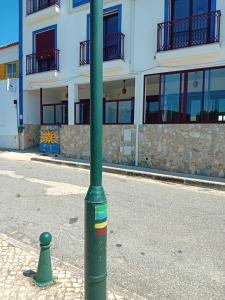 a green pole on a street in front of a building at Sol Mar in Odeceixe