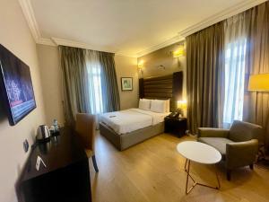a hotel room with a bed and a chair at The Sojourner By Genesis in Ikeja