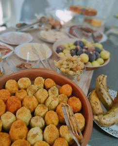 a table with plates of food and bowls of fruit at Sienda Cesira in Muravera