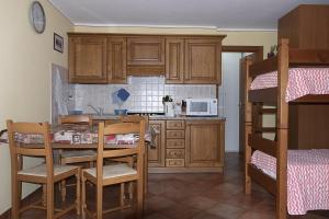 cocina con mesa y sillas y litera en Case Gran Paradiso Rhemes Notre Dame, en Rhêmes-Notre-Dame