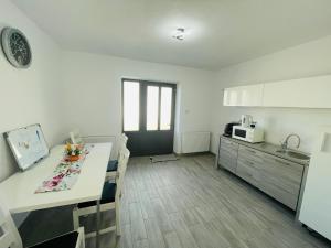 a room with a kitchen and a table with chairs at Cazare Balo in Zărneşti