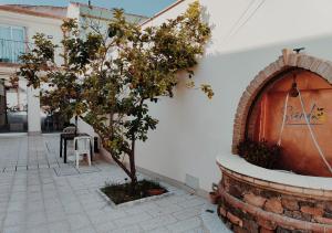 a tree in a courtyard next to a brick fireplace at Sienda Cesira in Muravera
