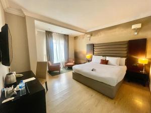a hotel room with a bed and a living room at The Sojourner By Genesis in Ikeja