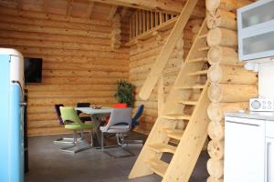 ein Esszimmer mit einem Tisch und Stühlen sowie Holzwänden in der Unterkunft Blockhaus eighteen in Rieden