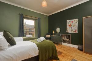 a green bedroom with two beds and a fireplace at Cosy, Stylish, Leafy And Homely in Sheffield
