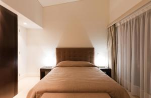a bedroom with a bed with a large headboard at Troia Residence by The Editory - Apartamentos Marina in Troia