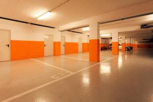 an empty parking garage with orange and white walls at Troia Residence by The Editory - Apartamentos Marina in Troia
