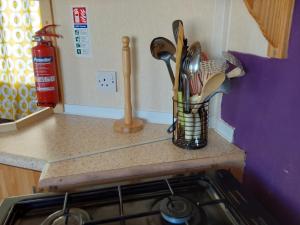 a kitchen counter with a container of utensils at Arizona Caravan in Camber +152 photos
