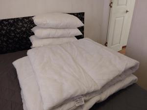 ein Stapel weißer Kissen auf einem Bett in der Unterkunft Arizona Caravan in Camber