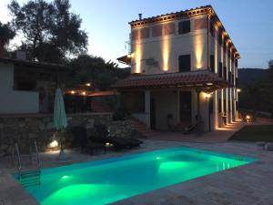a villa with a swimming pool in front of a house at Casale Olea in Massarosa