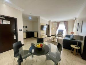 a living room with a table and chairs and a couch at The Sojourner By Genesis in Ikeja