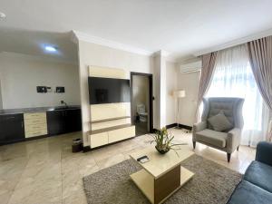 a living room with a couch and a tv at The Sojourner By Genesis in Ikeja