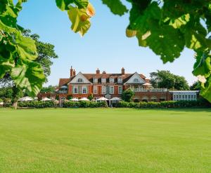 新米尔顿Chewton Glen Hotel - an Iconic Luxury Hotel的前面有绿地的大房子