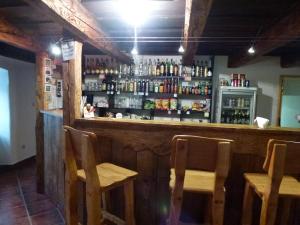 a bar with two chairs and a counter with bottles at Penzion Zelený Dvor in Veľká Lomnica