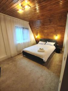 a bedroom with a large white bed with a window at Cabana A Brezoi in Brezoi
