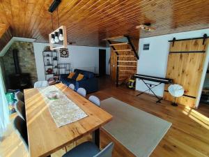 a living room with a wooden table and a piano at Cabana A Brezoi in Brezoi