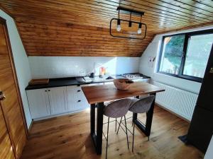 a kitchen with a wooden table and two chairs at Cabana A Brezoi in Brezoi