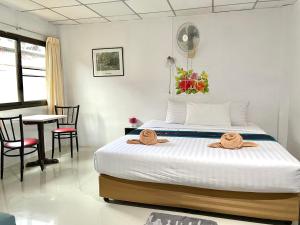 卡伦海滩JJ karon beach hotel的一间卧室，里面有一张床、一张桌子和几把椅子。