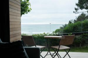 a patio with a table and chairs and the ocean at Balcobo Villas&Cabañas in A Coruña