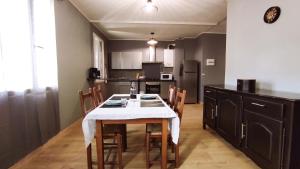 a kitchen with a table with a white table cloth at Gîte de la Beauze 2 in Aubusson