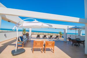 托雷斯的住宿－Ponta dos Molhes Beach Flat，阳台配有桌椅和遮阳伞。
