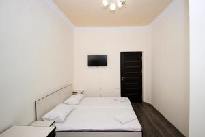 a bedroom with two beds and a tv on the wall at Hotel Victoria in Yerevan +47 photos