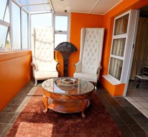 a living room with two chairs and a coffee table at Thandi's Guest House in East London