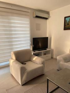 a living room with a couch and a flat screen tv at Sam Villa in Ulcinj