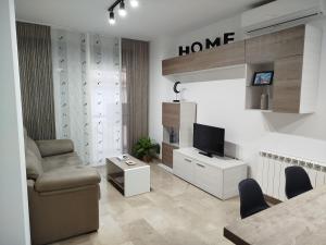 a living room with a couch chair and a television at Sentir CAZORLA in Cazorla