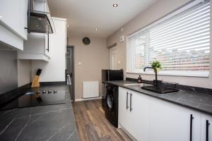 a kitchen with a sink and a washing machine at Modern Interior Spacious Four Bedroom Apartment in Westoe