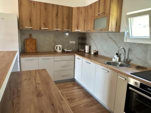 a kitchen with white cabinets and a wooden counter top at Nirvana in Tivat +26 photos
