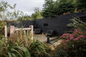 a garden with a fence and some pink flowers at The Burnopfield in Burnopfield