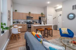 シンシナティにあるCentral Over-the-Rhine, 3 Lux Queen Beds, Steps to TQL, Findlay Market & Light Rail, Fast Wifi, Sleeps 7pplのソファとキッチンのあるリビングルーム