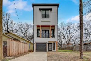 a white house with a black garage at Munice at Trinity Grove in Dallas